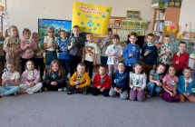 Grupa IX w sali z sylwetami kuli ziemskiej i transparentem  z okazji Dnia Ziemi.