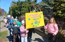 Dzieci z gr. IX podczas przemarszu z transparentem - Nasza moc. Nasza planeta.