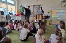 Pan pszczelarz prezentuje dzieciom elementy stroju pszczelarskiego.