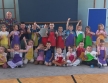 Zdjecie grupowe w kolorowych fartuszkach z instruktorem.