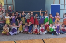 Zdjecie grupowe w kolorowych fartuszkach z instruktorem.