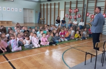 Przedszkolaki obserwuja jak nauczyciel gra na saksofonie.