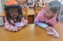 Dziewczynka w kasku ochronnym lesnika.