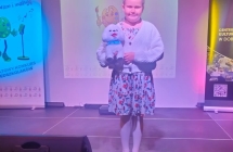 Dziewczynka na scenie z pluszowym pieskiem.