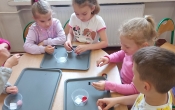 Dzieci wykonuja eksperyment z magnesami