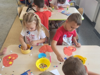 Dzieci z grupy Wiewioreczki wykonuja prace plastyczna Kwiat Przyjazni.