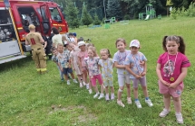 Dzieci z grupy Wiewi+-reczki z medalami stoj¦u obok wozu stra+-ackiego.