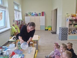 1. Dzieci obserwuja wlewanie wody do pojemnikow.