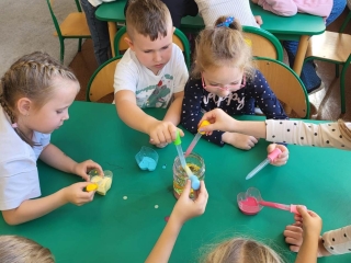 Zabawy i eksperymenty podczas Dnia Kropki w grupie Wiewioreczek. Dzieci za pomoca pipet tworza kolorowe kropkowe wulkany.