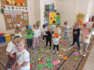 Maluszki na dywanie podczas zabawy z kropkami.