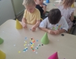 5. Dzieci przyklejaja kolorowe kropki na czapeczkach