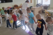 4. Dzieci trzymajac sie za rece ida po tasmie.